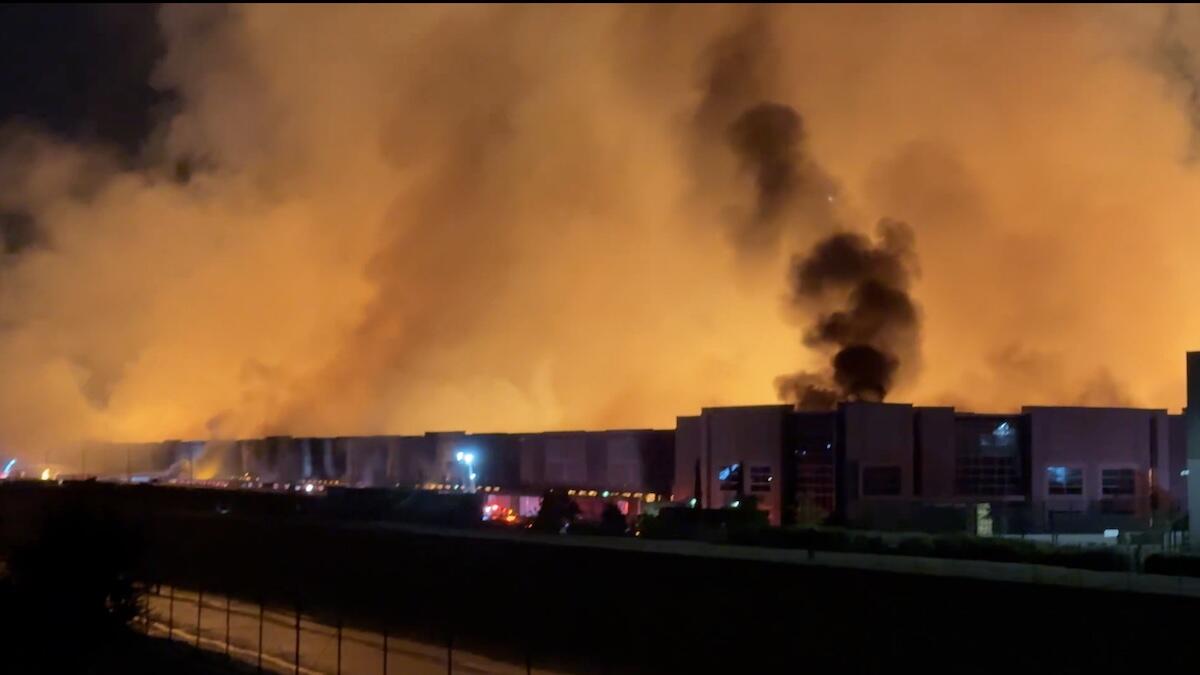 Arson suspect arrested after fire engulfs major company's warehouse