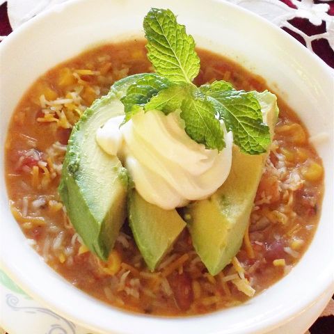 Stew with avocado and sour cream garnish