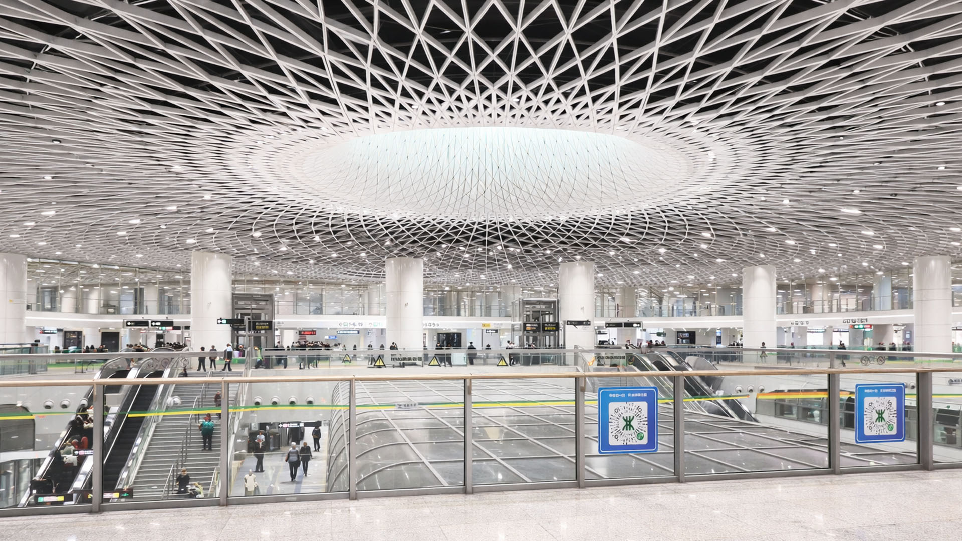 Notice a public transport station with a large central ceiling feature