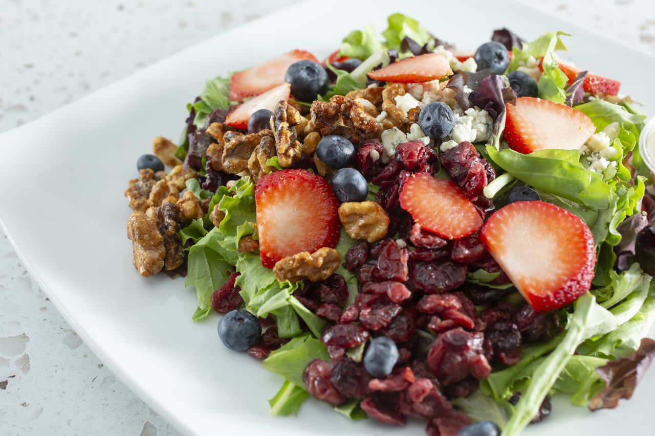 Salad topped with walnuts and fruit