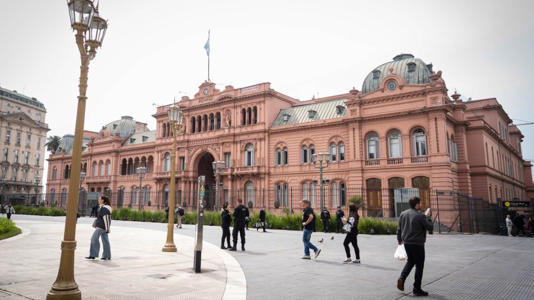 Fotogaleria Personas caminan frente a la Casa Rosada, sede del gobierno argentino, en la ciudad de Buenos Aires, capital de Argentina. Los valores del peso argentino, junto a las acciones y los títulos públicos del país