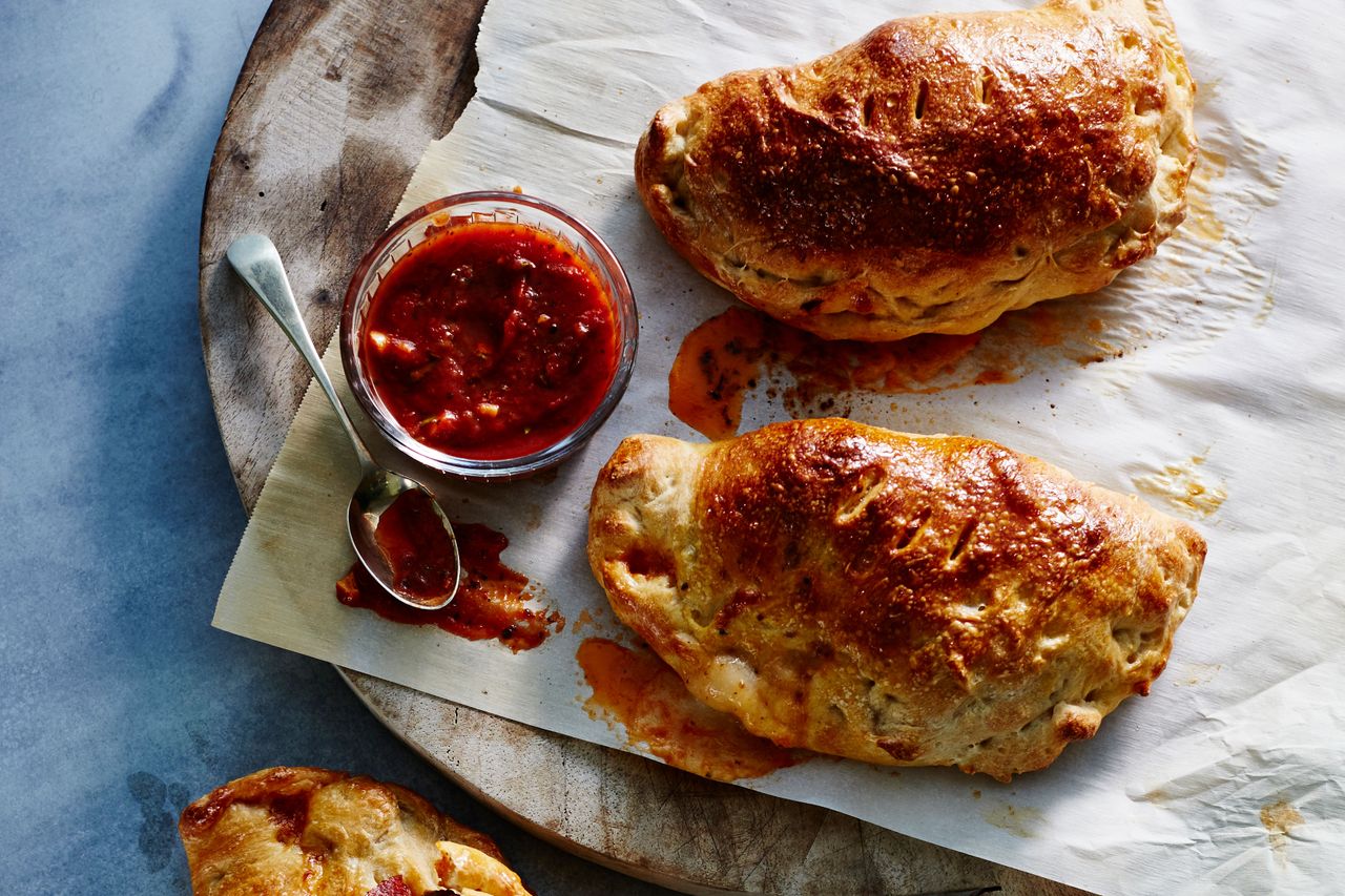 beef calzones with a bowl of tomato sauce