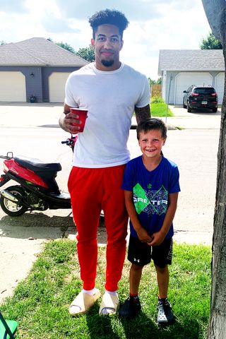 Lonely child running roadside lemonade stand approached by football ...