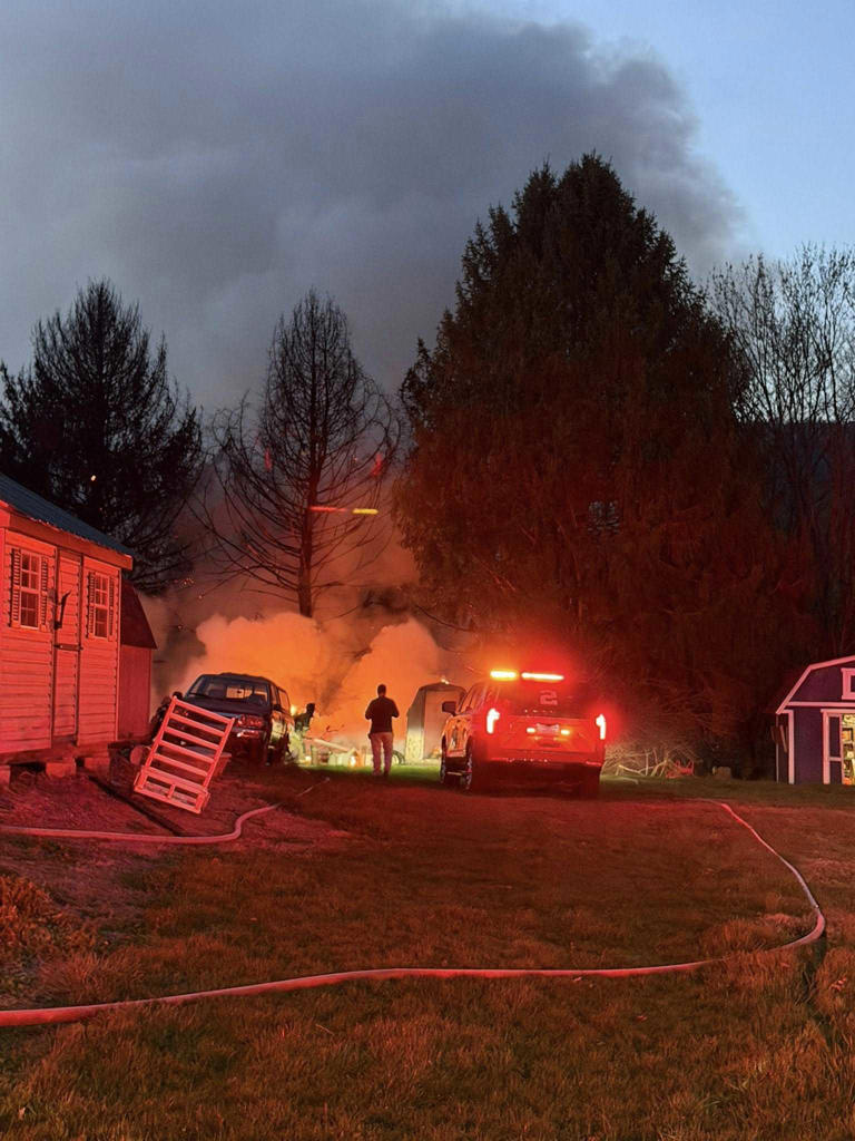 Heavy flames engulf multiple sheds, trees