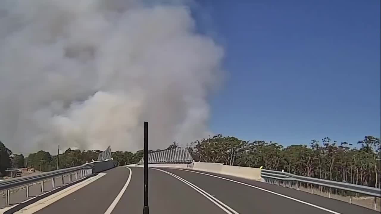 Thick smoke looms over highway during bushfire in Australia