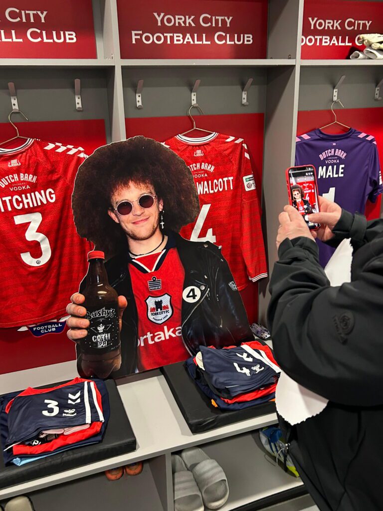 Friends wear masks of late fan’s face at match in tribute