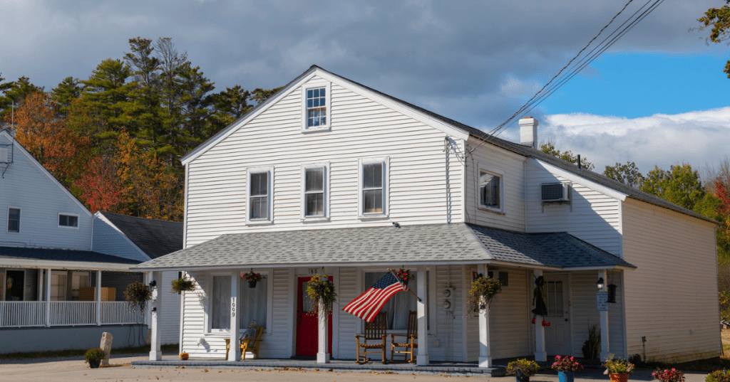 An old-fashioned white building in Moultonborough, New Hampshire, with an American flag flying outside.