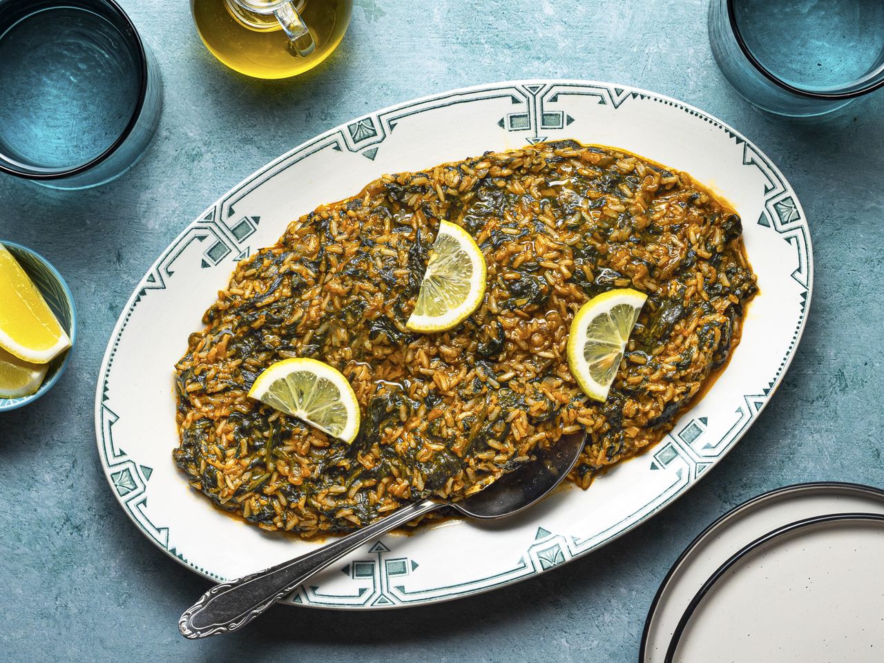 A dish of spanakorizo garnished with lemon slices