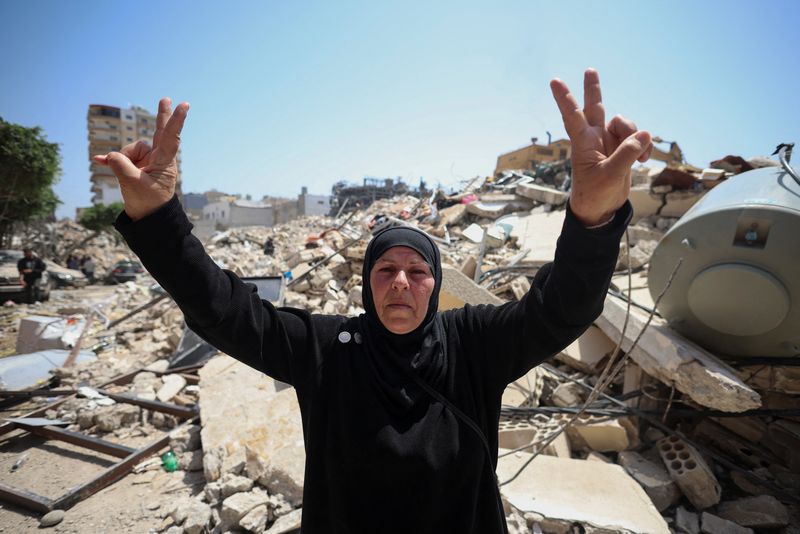 A woman makes a peace sign at the site of an Israeli strike carried out before a 10-day ceasefire between Lebanon and Israel went into effect, in Tyre, Lebanon, April 17, 2026. REUTERS/Louisa Gouliamaki