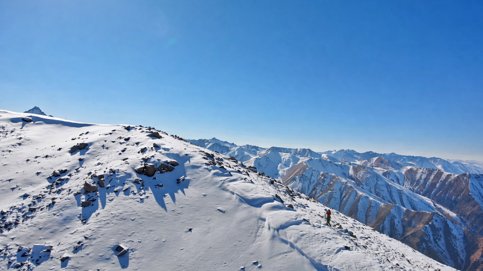 A snowy ridge path suspended high above the mountains
