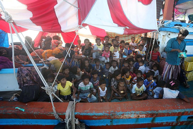 Rohingya children wait for food supply delivered by local fishermen on their boat anchored in the waters near the coast of Labuhan Haji, 22 October, 2024 AP Photo