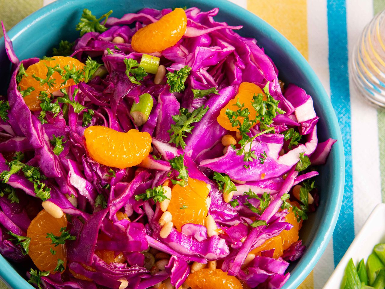 top-down view of Purple Cabbage Salad with mandarin orange segments and chopped parsley in a blue bowl