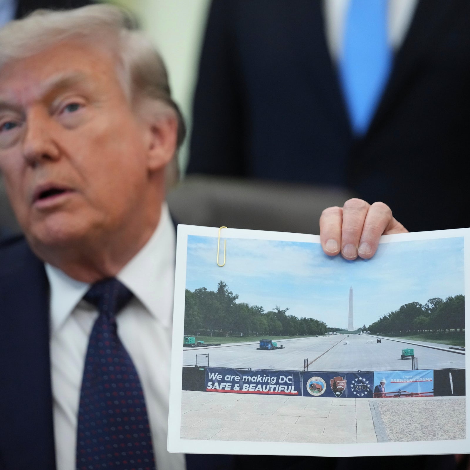 President Trump holds an image of the Lincoln Memorial Reflecting Pool during an event on health care affordability in the Oval Office at the White House, Thursday, April 23, 2026, in Washington.