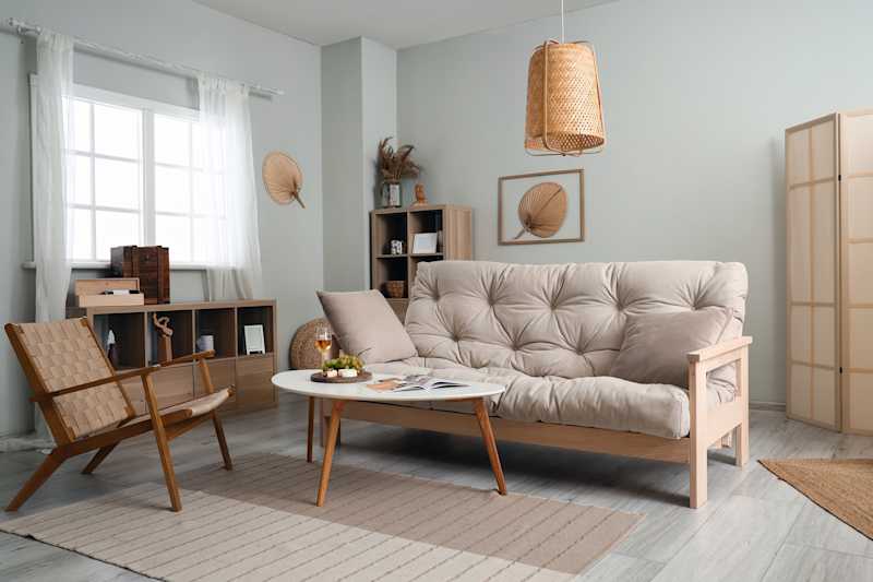 Interior of light living room with couch, armchair and table