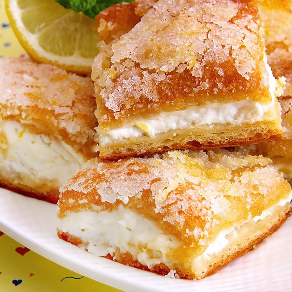 a close up, low angle view of a stack of lemon cream cheese bars