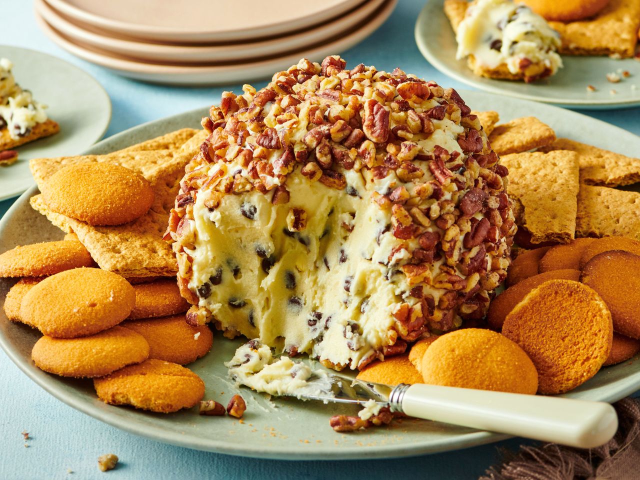 Dessert cheese ball covered in pecans served with assorted crackers and cookies