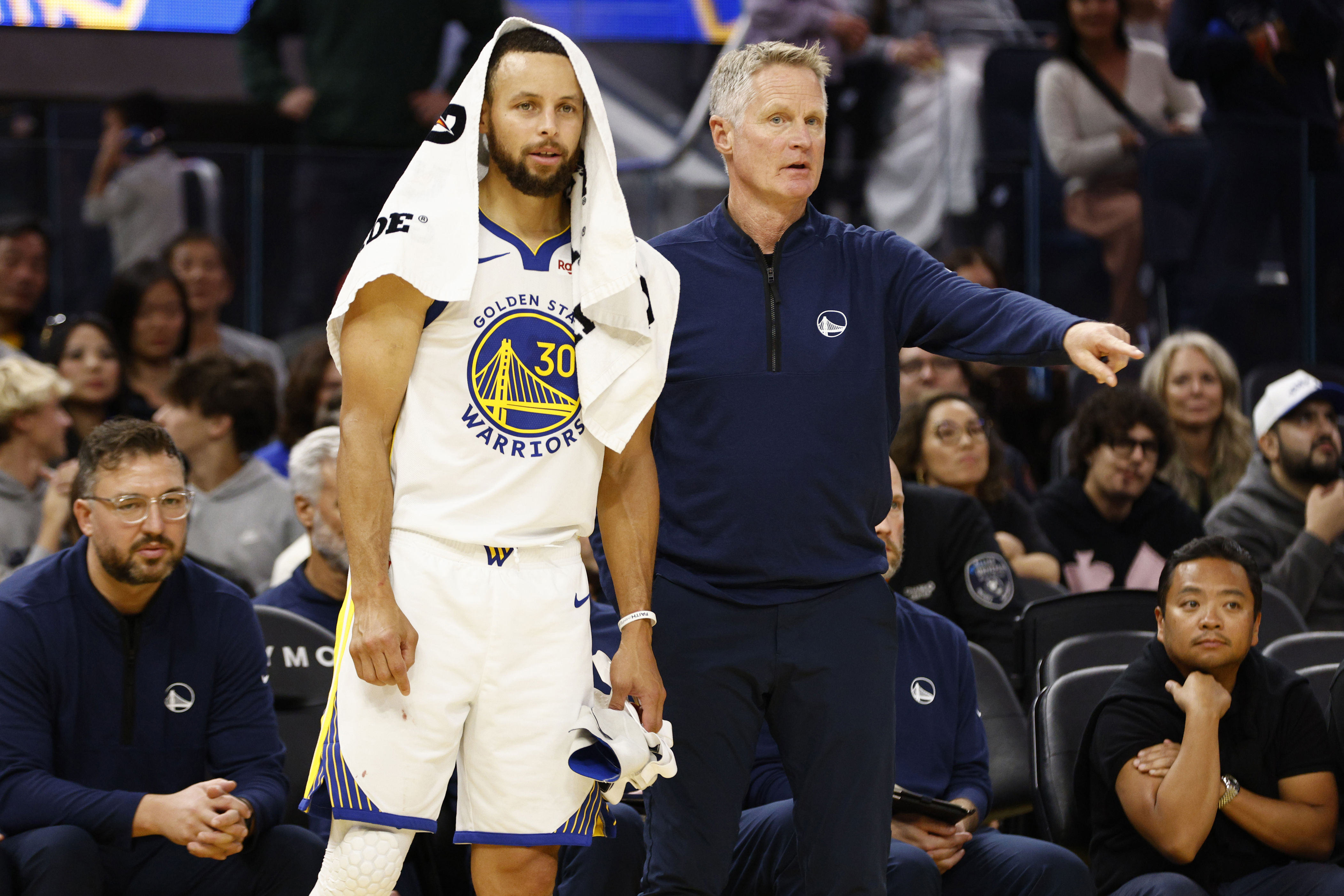 Steve Kerr standing next to Steph Curry