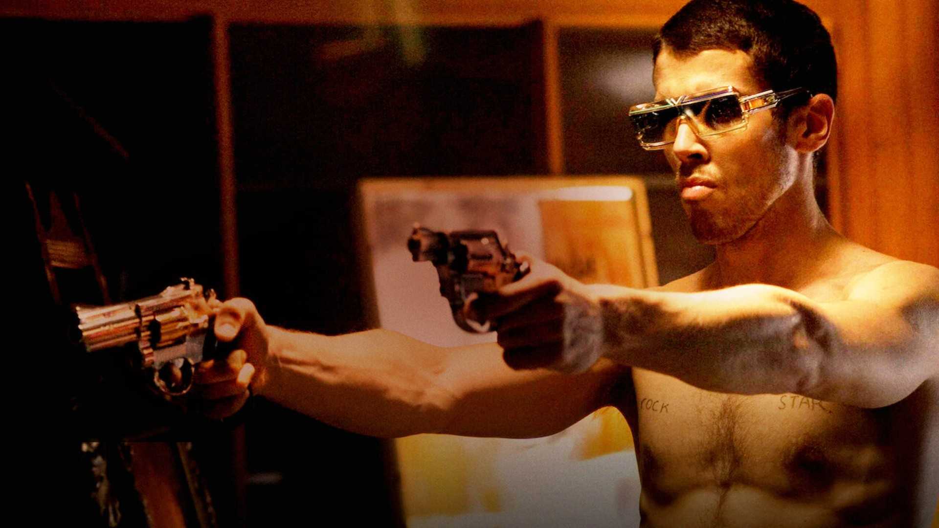 a man holds two pistols in RocknRolla