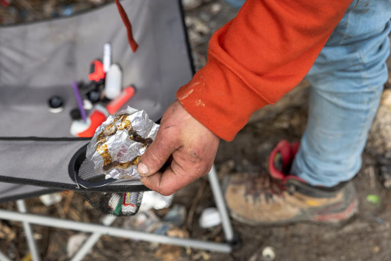 A homeless man holds a piece of aluminum foil he used to smoke fentanyl in Seattle, Washington, on March 13, 2022. Getty Images