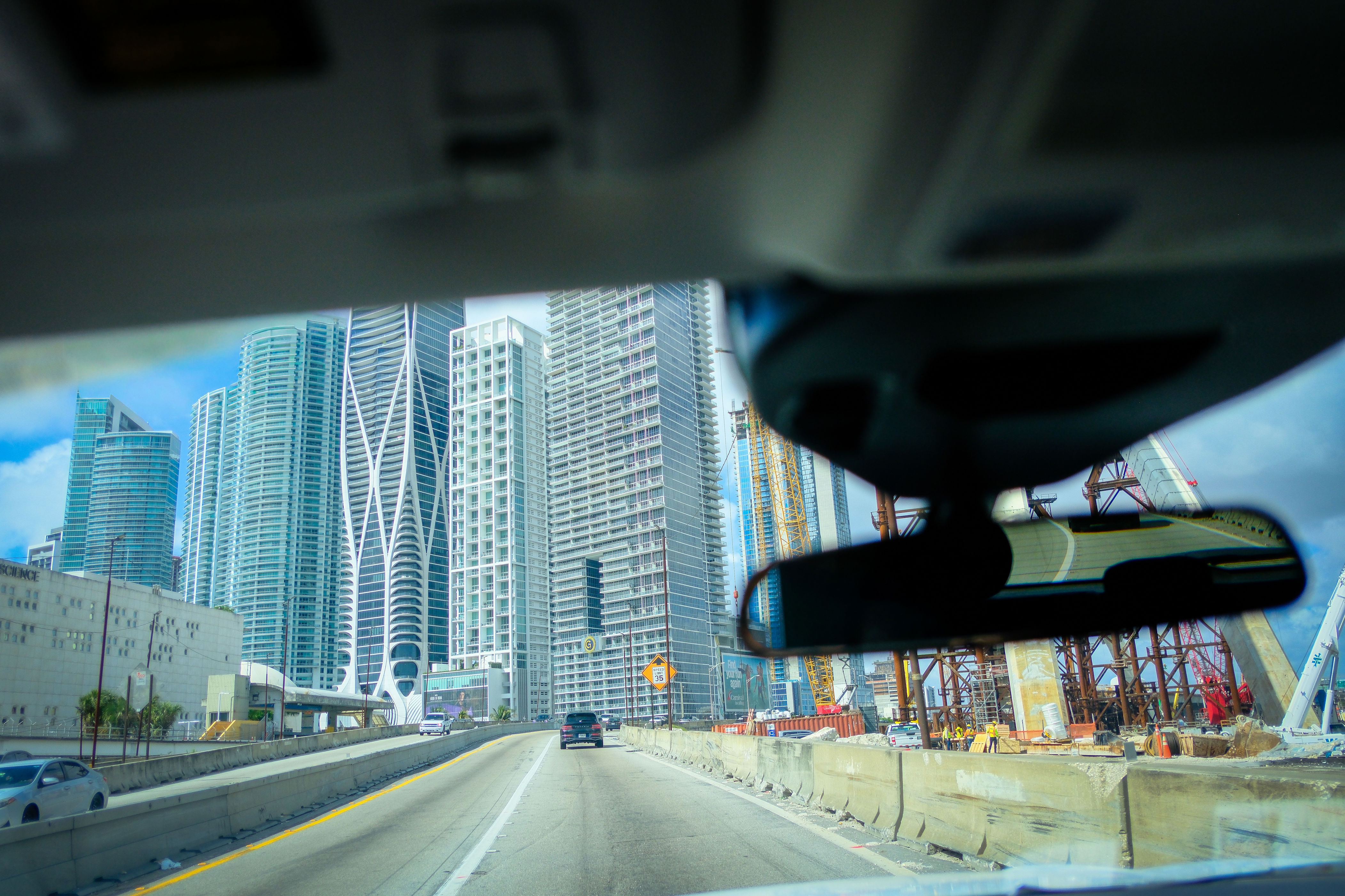 Driving on a freeway through an urban city in the USA showing urban hirise buildings from the drivers point of view.