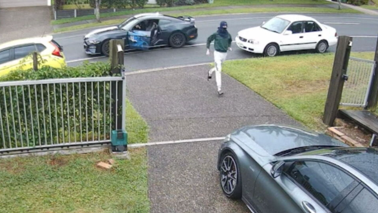 CCTV shows a hooded thief with a large knife getting out of the blue Mustang and trying to start an unlocked car in the driveway of a home on the Gold Coast yesterday morning.