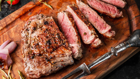 A medium rare grilled ribeye steak