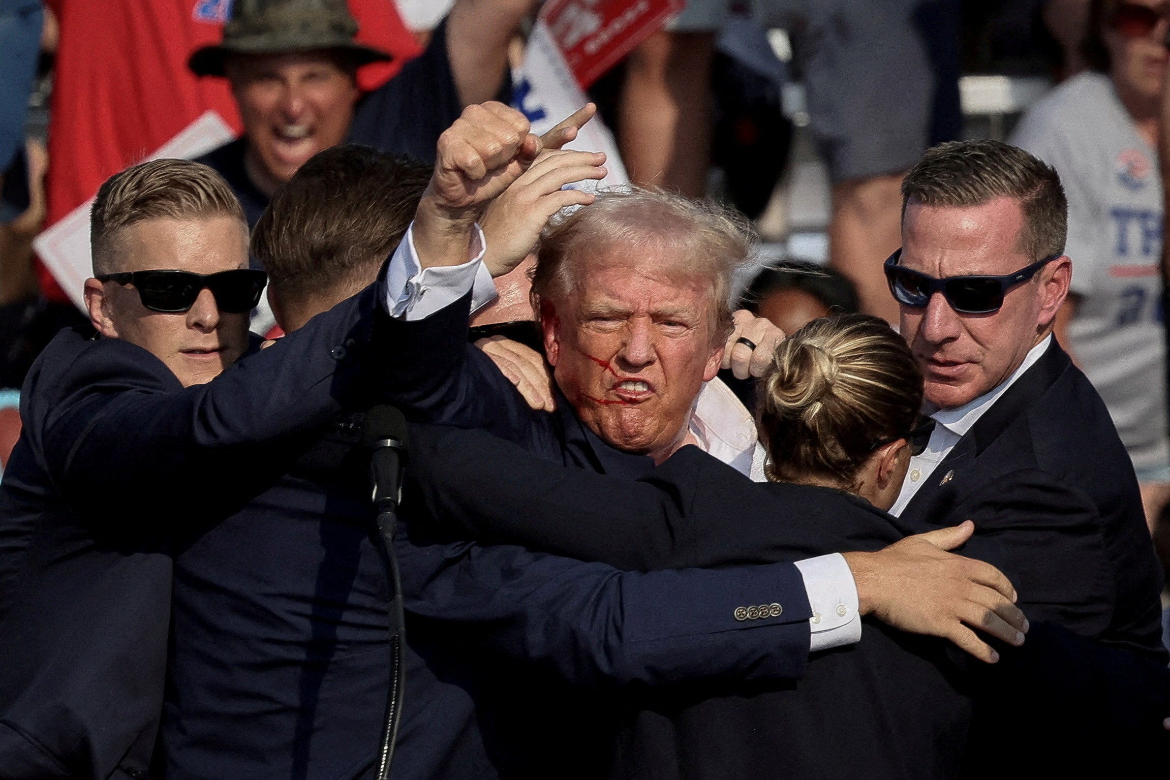 Republican presidential candidate and former U.S. President Donald Trump is assisted by the Secret Service after gunfire rang out during a campaign rally at the Butler Farm Show in Butler, Pennsylvania on July 13, 2024.