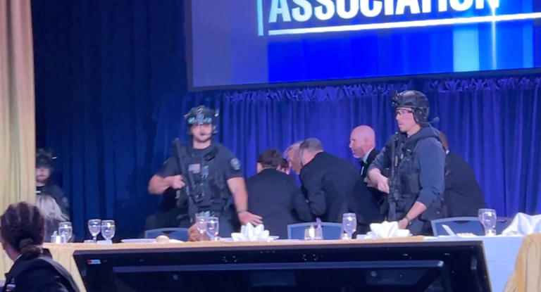 A still from video shows the president being escorted out.