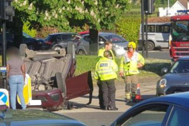 Car ends up on its roof after crash at roundabout