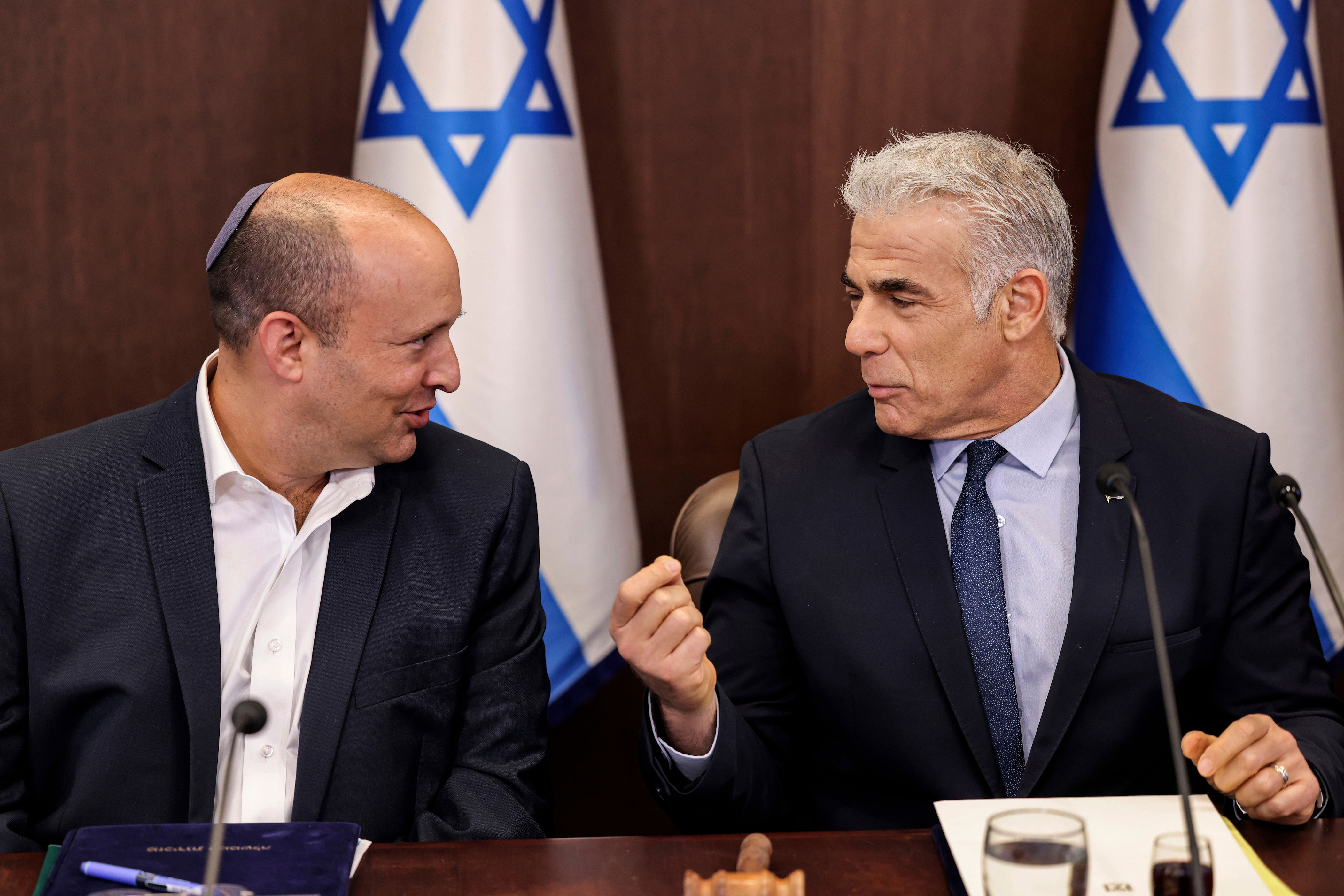 Israel's then caretaker Prime Minister Yair Lapid (right), talks with former Prime Minister Naftali Bennett during the weekly cabinet meeting in Jerusalem, on Sunday, Sept. 18, 2022.