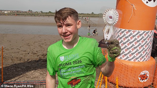 Albert Crates (pictured) managed to run, walk and crawl his way to victory on Sunday across a 440m stretch of the muddy River Blackwater in Essex - making him the youngest person to win the race