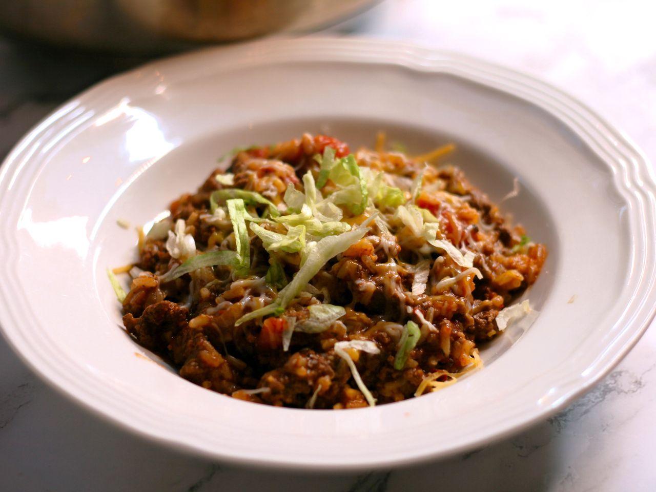 ground beef-cheese mixture topped with lettuce on white plate