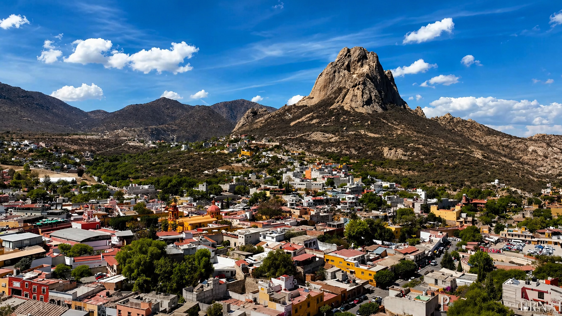 Colorful town beneath giant rock mountain