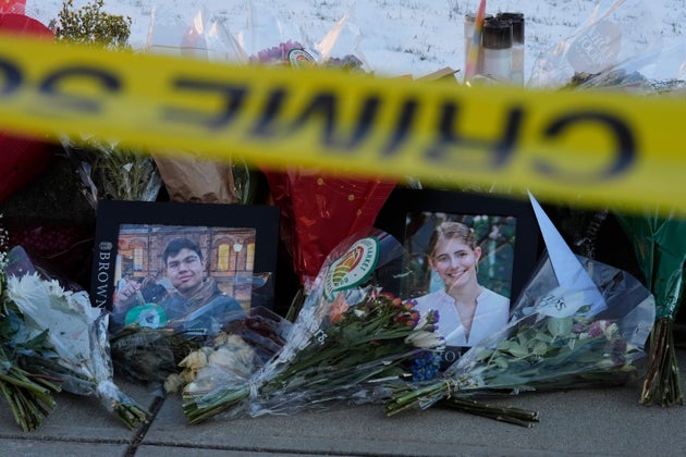 Photos of Brown University shooting victims MukhammadAziz Umurzokov and Ella Cook are placed among flowers at a makeshift memorial in Providence, Rhode Island, on Dec. 16, 2025.