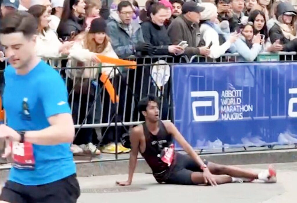 Moment marathon runners stop to carry injured competitor over finish line