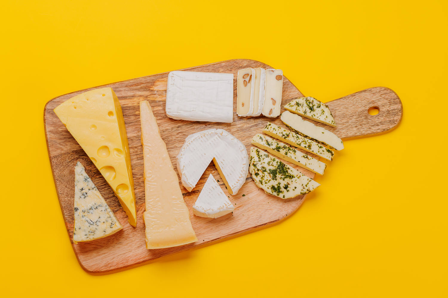 An assortment of various cheeses arranged on a board, highlighting different textures