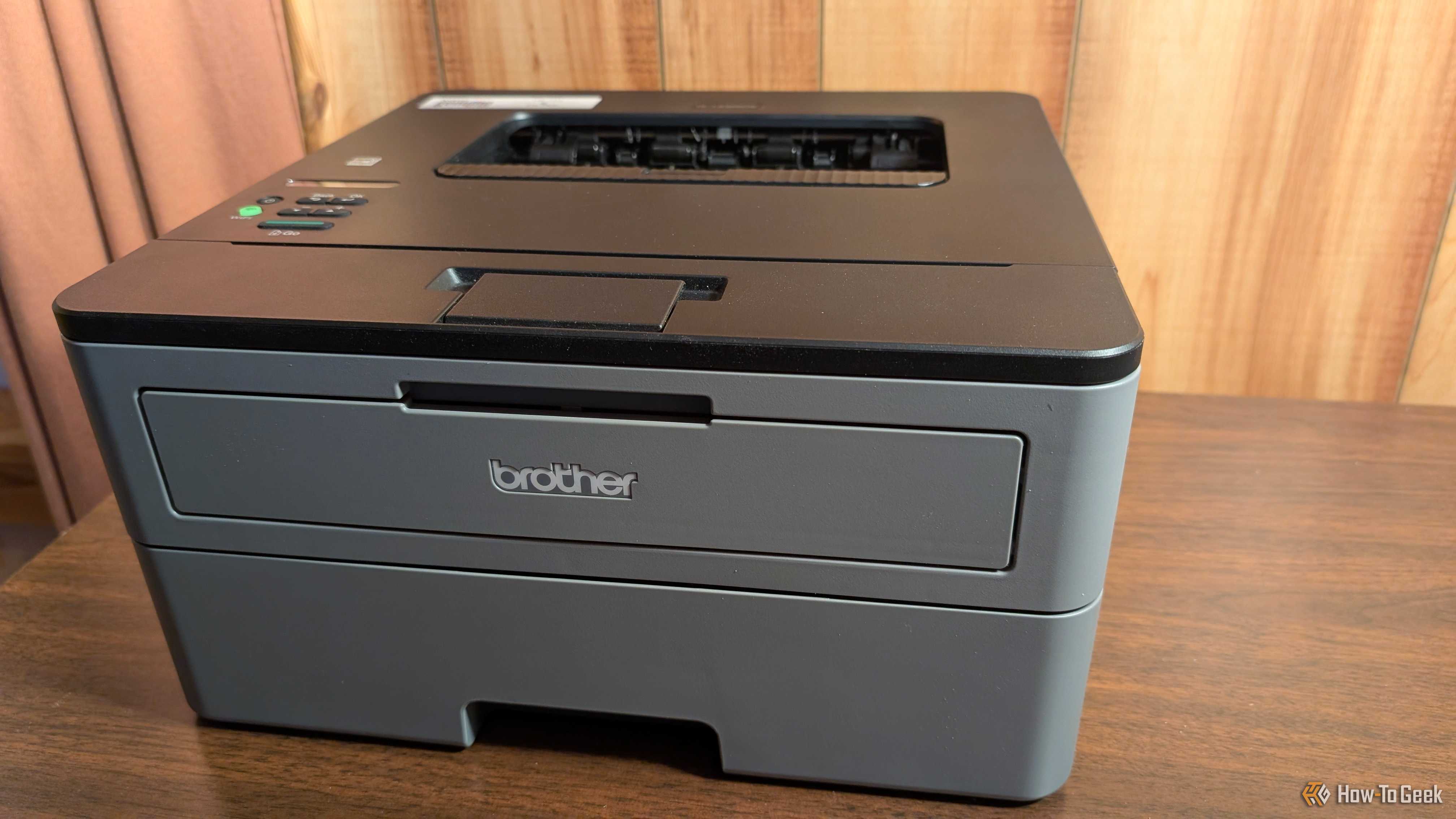 A Brother monochrome laser printer sitting on a desk.