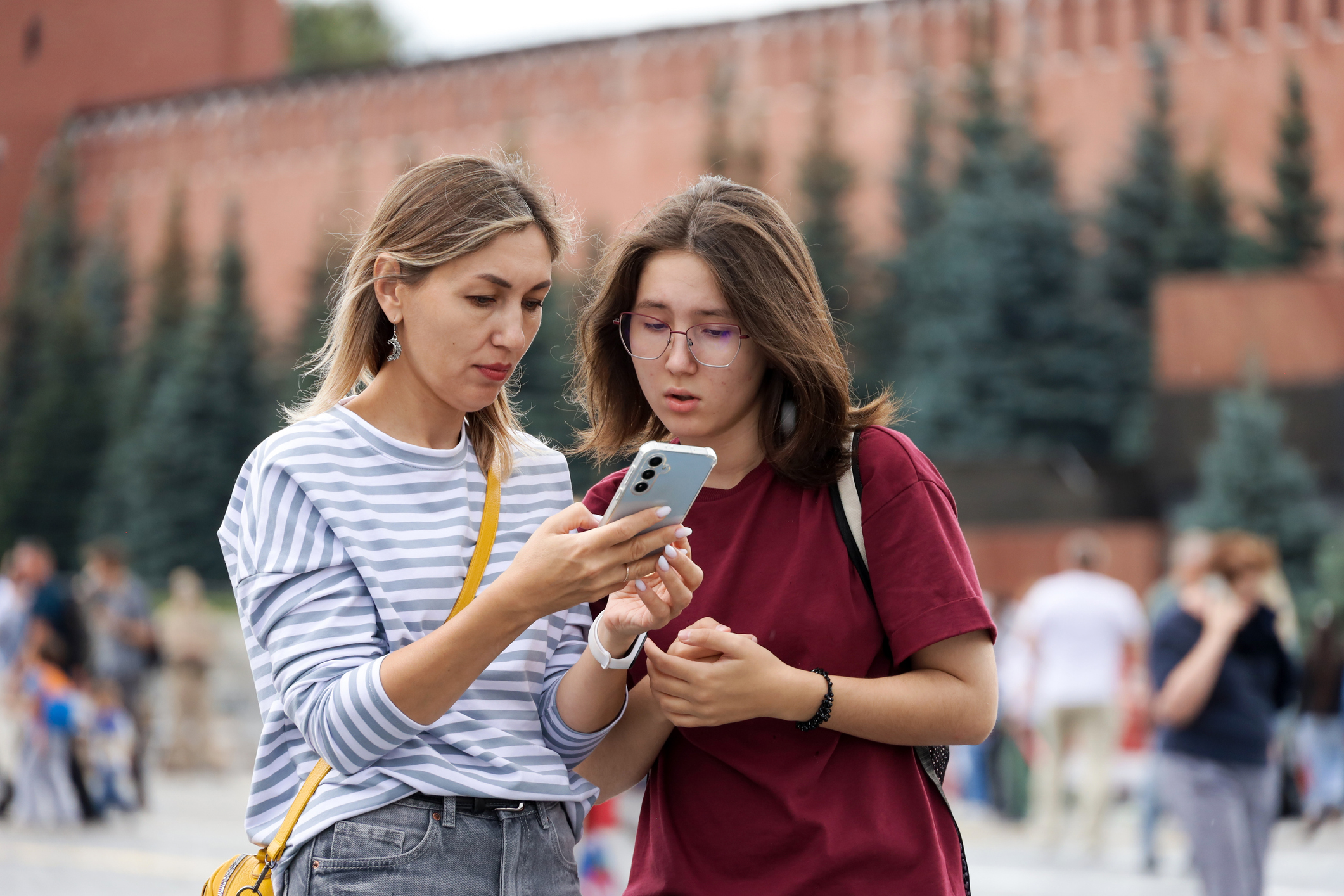 Worried woman and girl looking at smartphone screen on Red square in Moscow, Internet disconnection and restrictions
