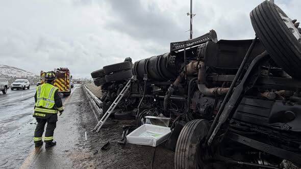Semi truck rolls over on I-70 spilling diesel on the road