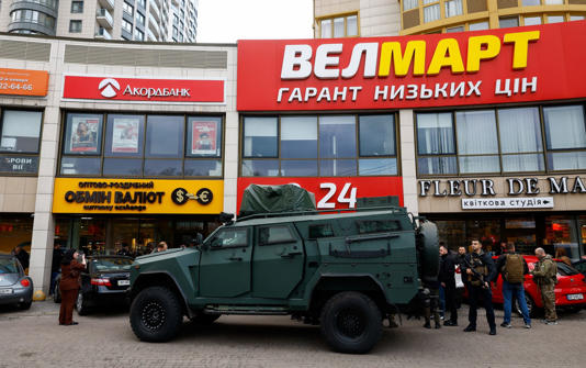 An armoured vehicle outside the supermarket in Kyiv where a gunman killed five people before being shot dead by armed officers - Reuters