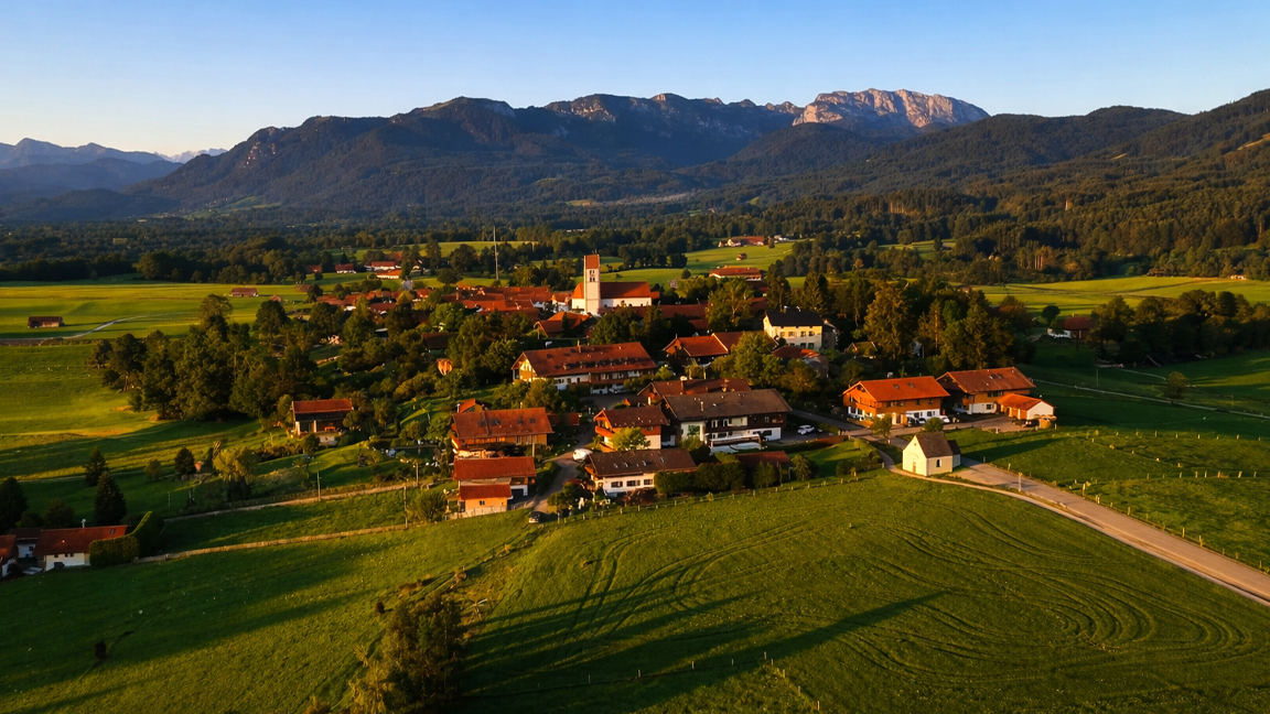 Charming countryside village surrounded by green fields and mountains
