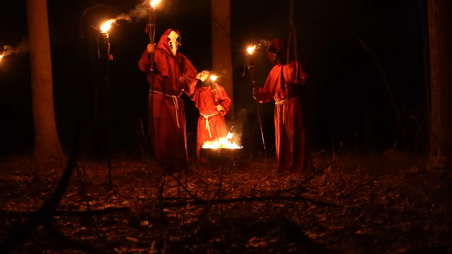 Group filming at night captures figures performing a disturbing ceremony