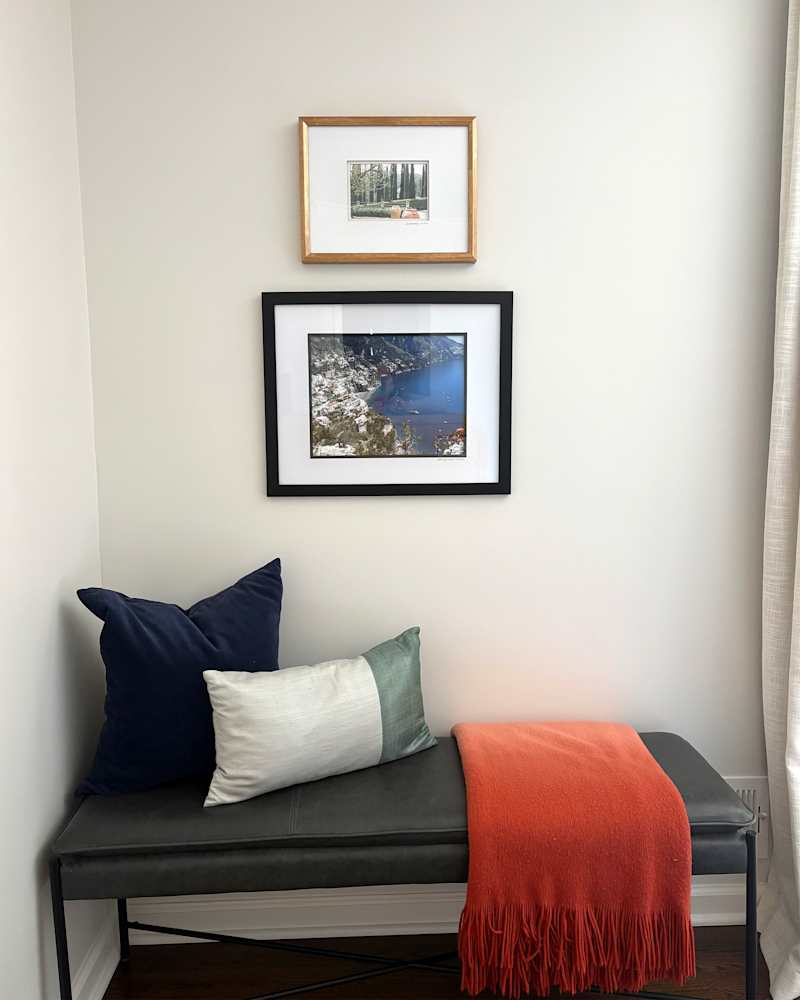 Framed vacation photos above bench.