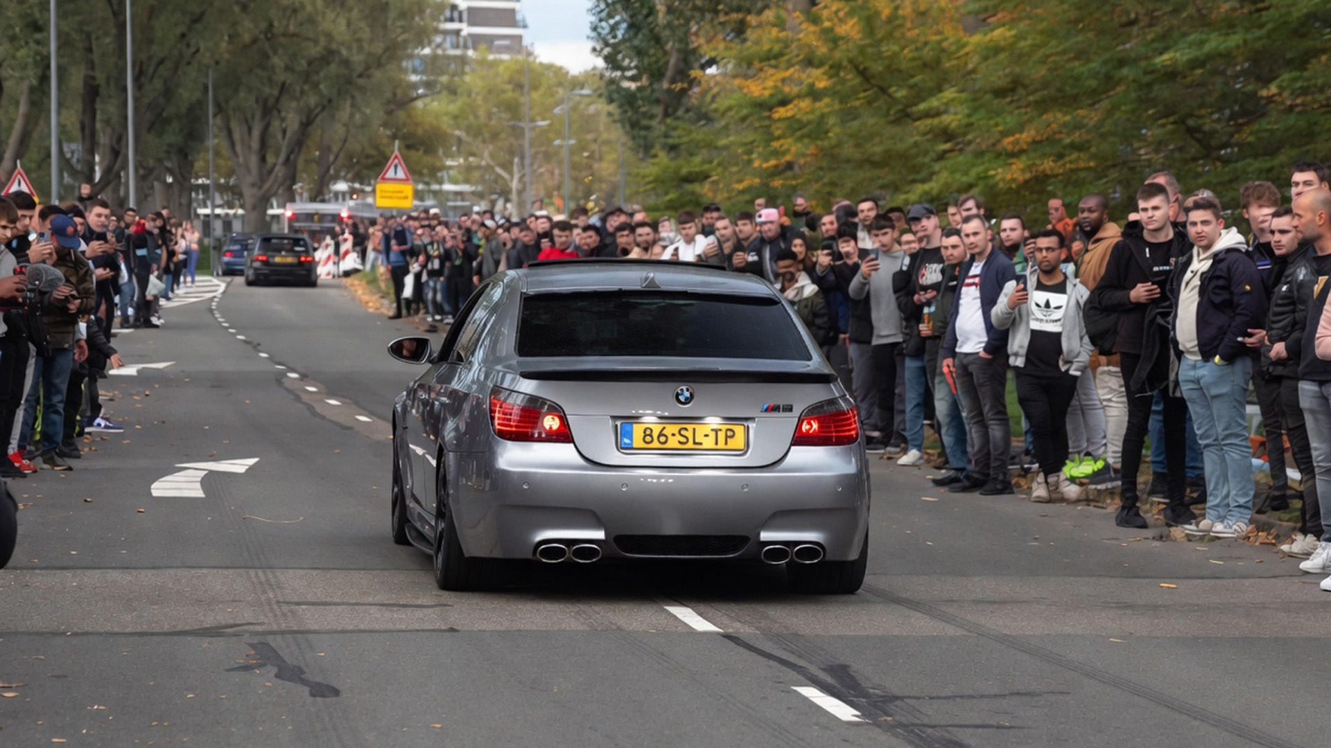 BMW M5 with high-end exhaust roaring loud in front of crowd