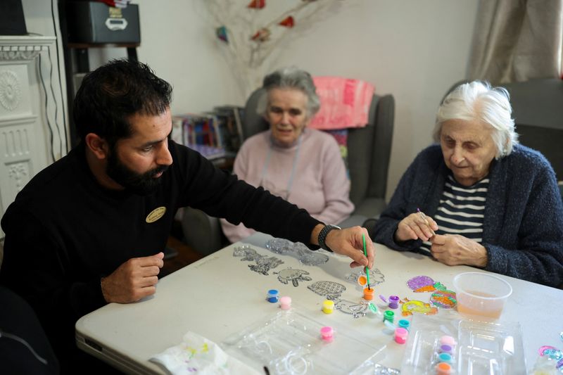 Deputy manager Kuldeep Singh interacts with elderly residents at Applegarth Care Home, as the care sector braces for crisis over the British government's plans to reduce migration numbers, in Maidenhead, Britain, March 11, 2026. REUTERS/Isabel Infantes