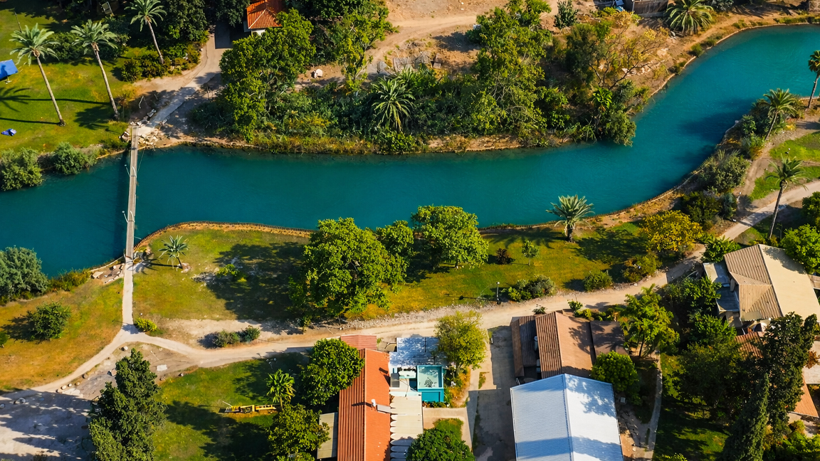 Scenic river flowing through tropical village and lush trees