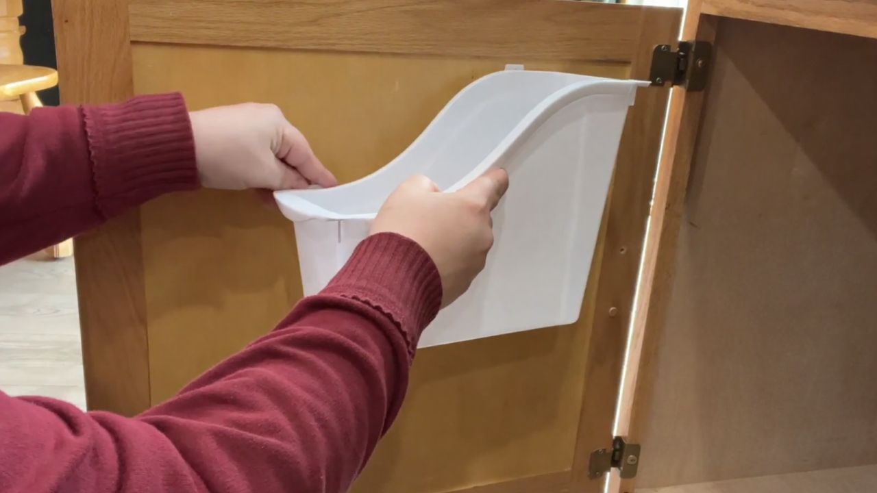 Put a Dollar Store book bin in your kitchen cabinet (this is genius!)