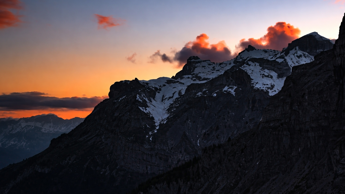 High mountain cliffs at sunset with soft cloud highlights