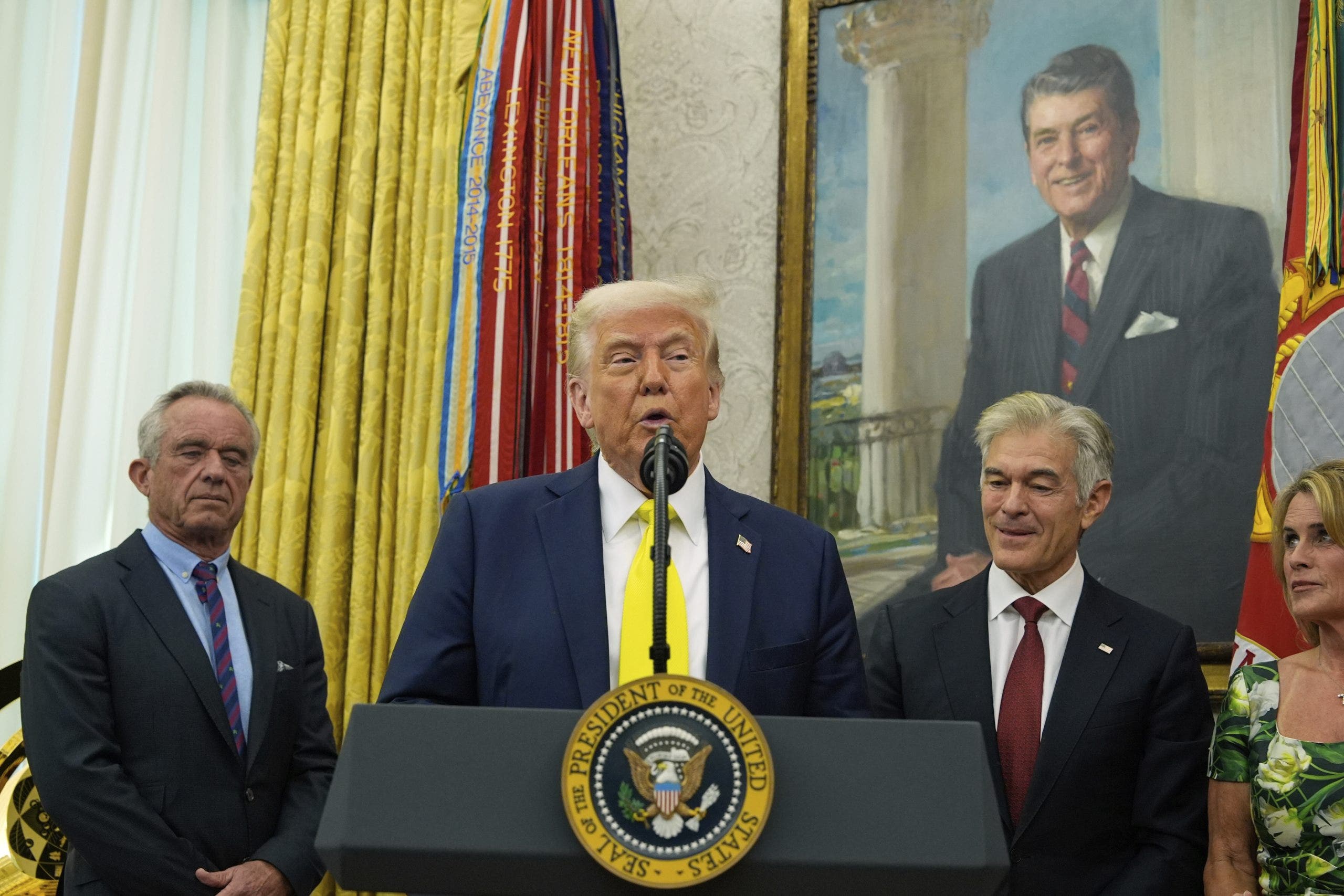 President Donald Trump speaks as Health and Human Services Secretary Robert F. Kennedy Jr., from left, Dr. Mehmet Oz, and Oz's wife Lisa Oz listen during a swearing in ceremony for Oz to be Administrator of the Centers for Medicare and Medicaid Services, in the Oval Office of the White House, Friday, April 18, 2025, in Washington.