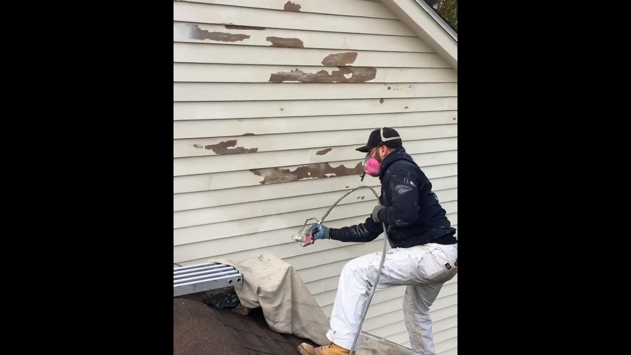 Exterior wall spray painting process producing clean and fresh house look